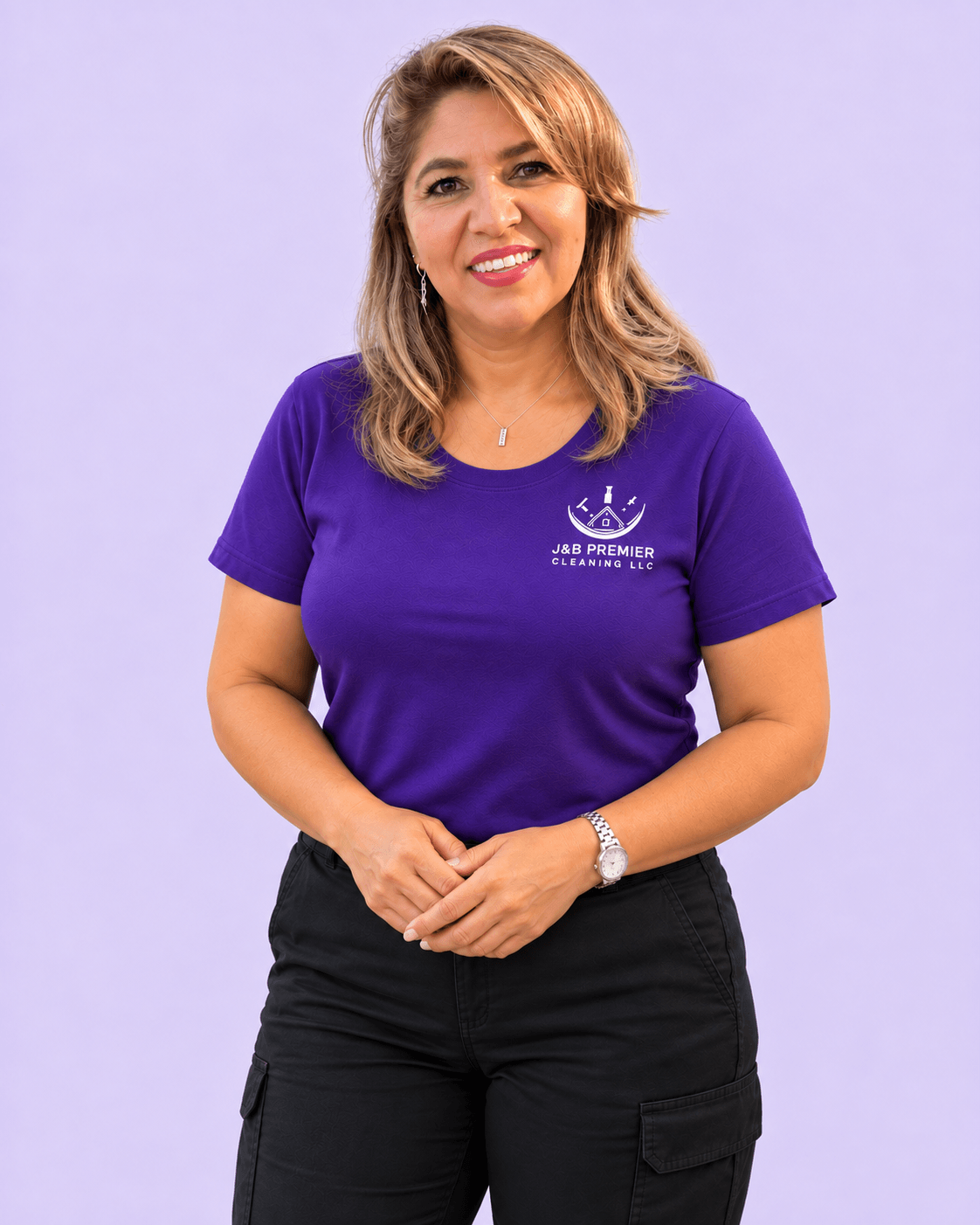 A smiling J&B Premier Cleaning professional posing with her hands gently clasped